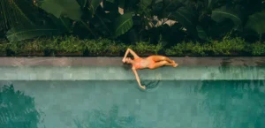 A woman lying at the pool creating a UGC for hotel marketing.