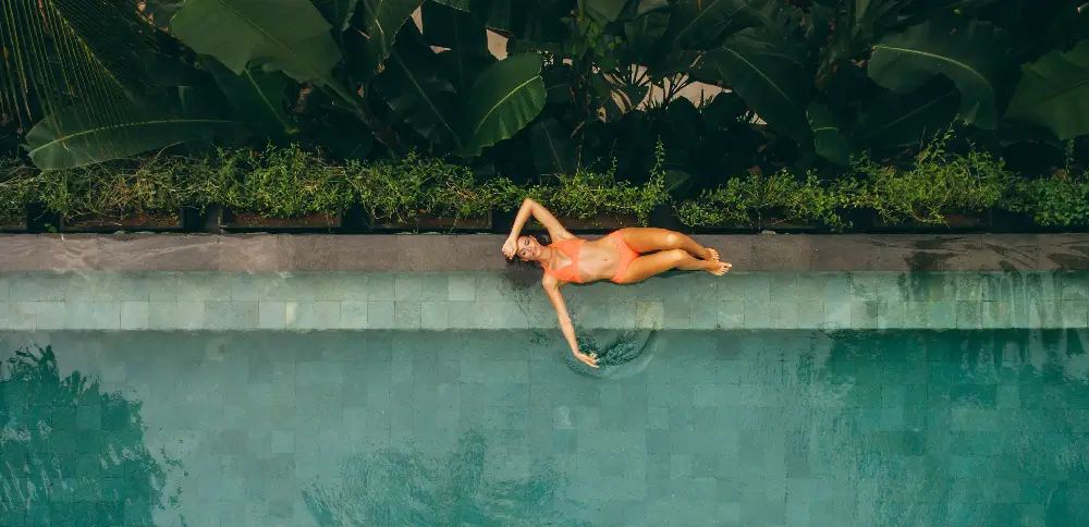 A woman lying at the pool creating a UGC for hotel marketing.