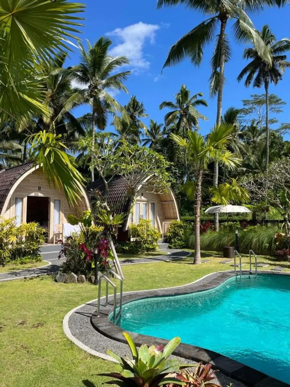 Enjoy the outdoor pool at The Mulia Bali, surrounded by lush palm trees, a perfect example of a Bali resort all-inclusive.