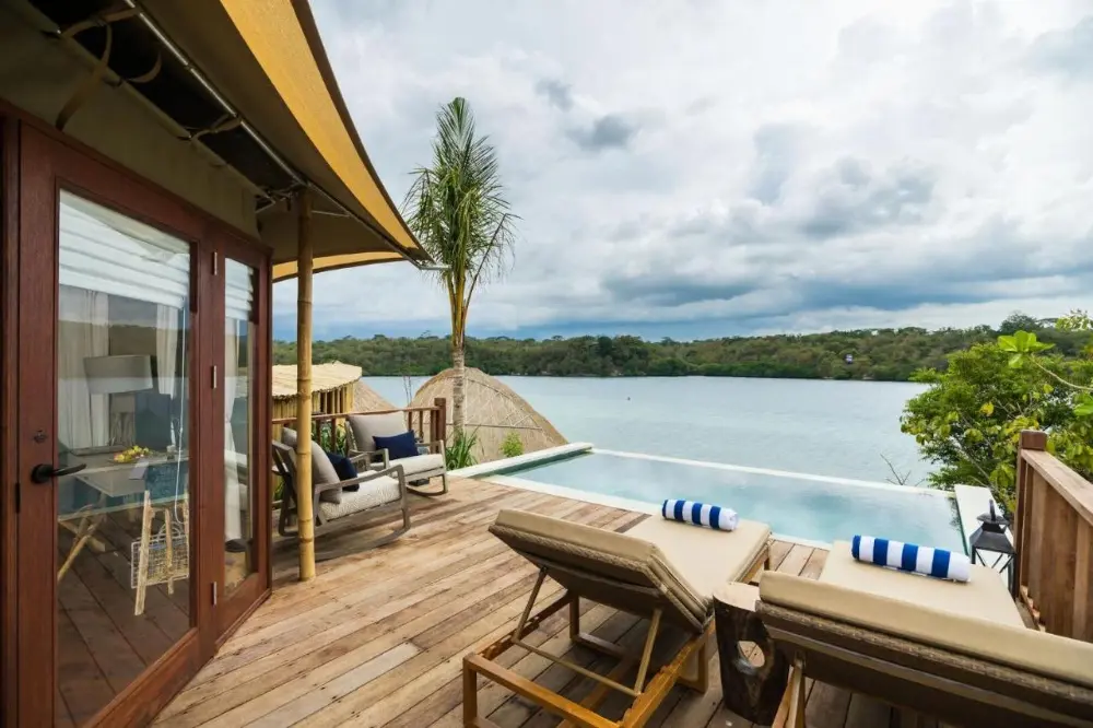 At Menjangan Dynasty, a lovely beach resort in Bali, lounge chairs on a deck offer a peaceful perspective of the ocean.