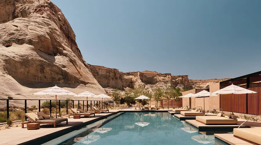 A serene pool at Amangiri, surrounded by rocks and sun umbrellas, perfect for relaxation at one of the best desert hotels worldwide.