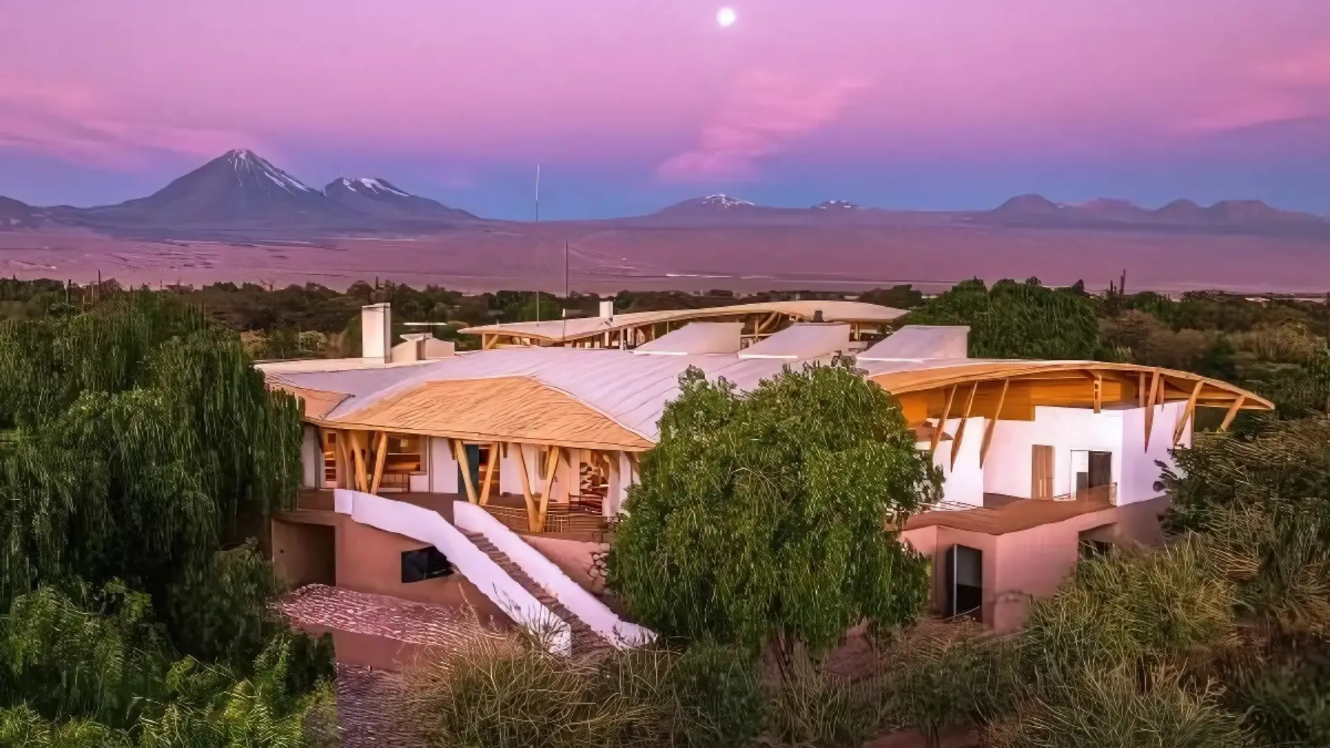 A cosy house nestled among trees and mountains, showcasing the beauty of nature near Explora Atacama, one of the best desert hotels worldwide.