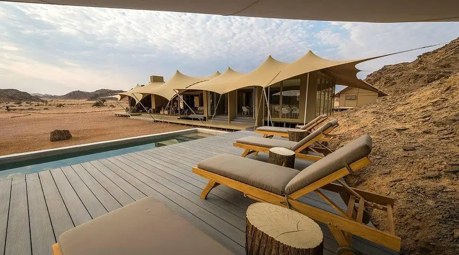 A cosy tent at Hoanib Skeleton Coast Camp, one of the best desert hotels worldwide, set up in the beautiful desert landscape.