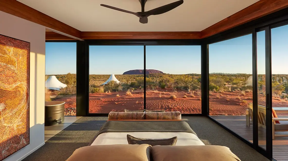 Relax in a bedroom at Longitude 131°, one of the best desert hotels worldwide, with a beautiful view of red rock.