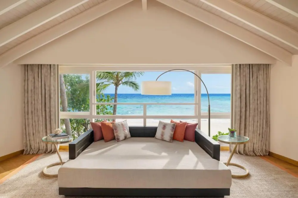 Elegant bedroom with a cozy bed and breathtaking ocean views, located in the JW Marriott Resort and Spa, a family hotel in Maldives.