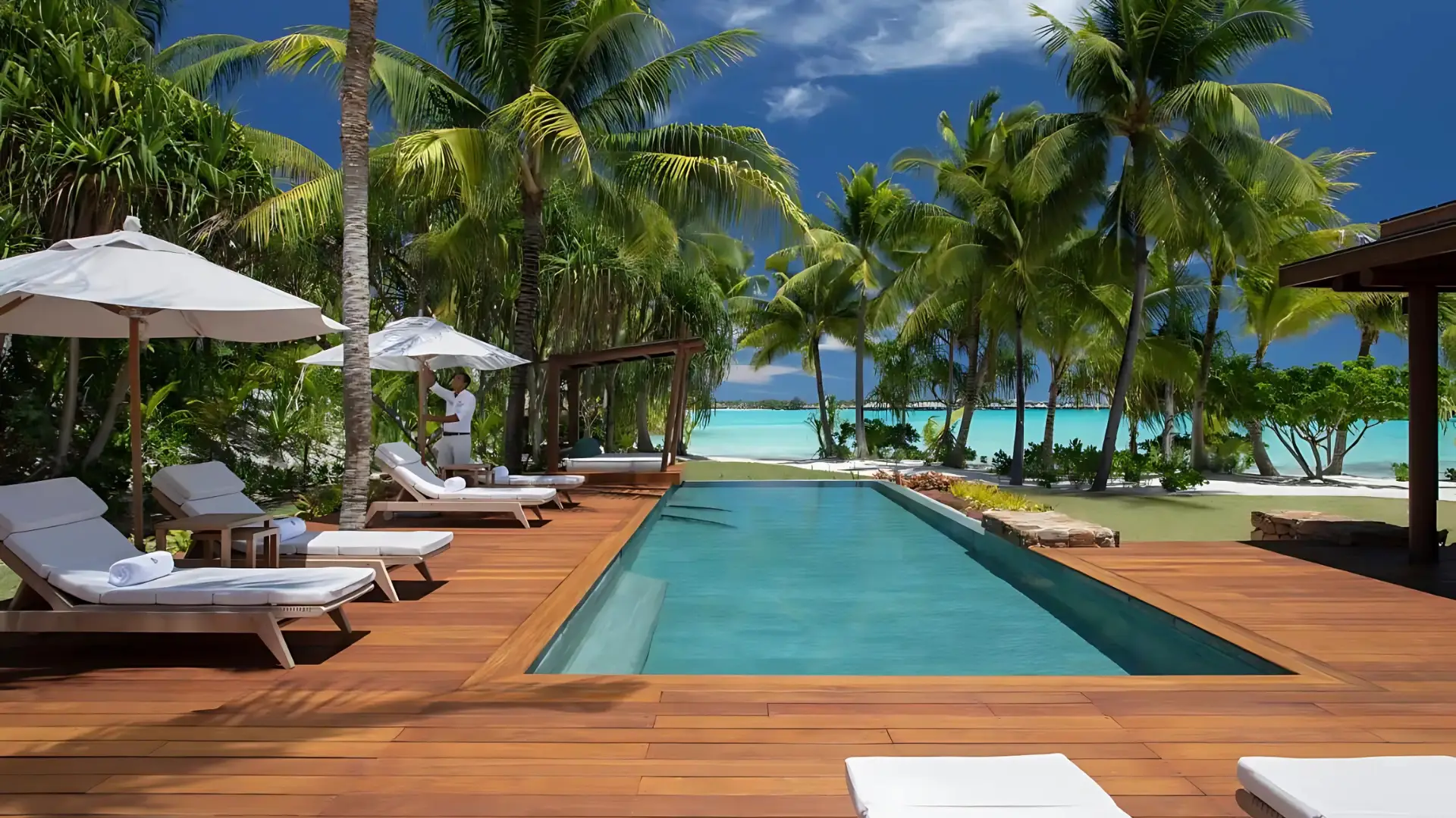 A stunning view of the Four Seasons Resort Bora Bora, featuring a pool and charming thatched roofs, one of the best Four Seasons hotels in the world.