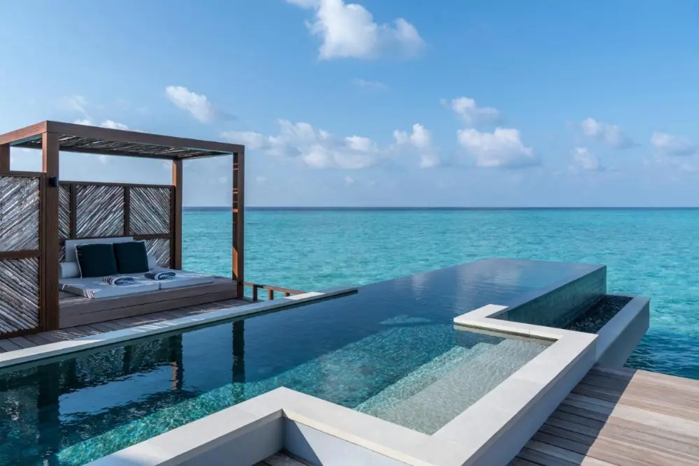 A stunning pool at Four Seasons Resort Maldives at Landaa Giraavaru, one of the best Four Seasons hotels in the world, with breathtaking views of the ocean and blue sky.