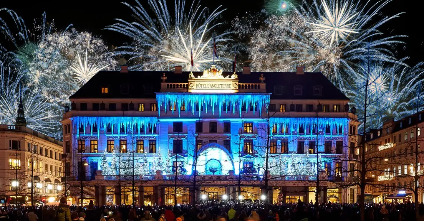 Hotel d’Angleterre, one of the best hotels for New Year’s Eve in Copenhagen, highlighted with a lot of stunning fireworks behind it.