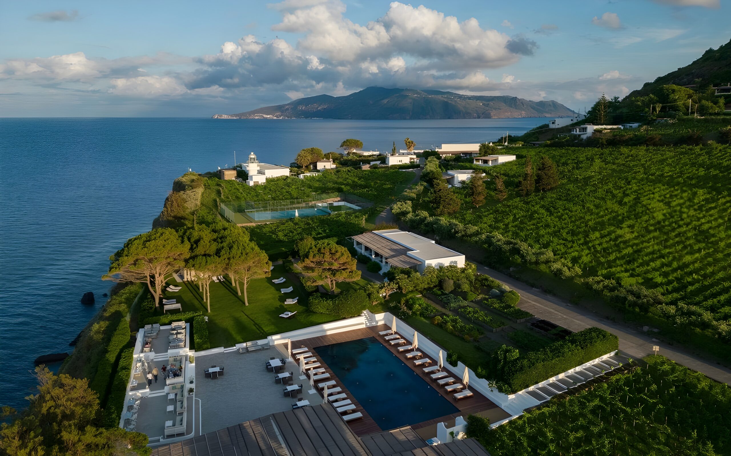 Scenic aerial view featuring the ocean and a swimming pool at Capofaro Locanda & Malvasia, a top hotel in Sicily with private beach.