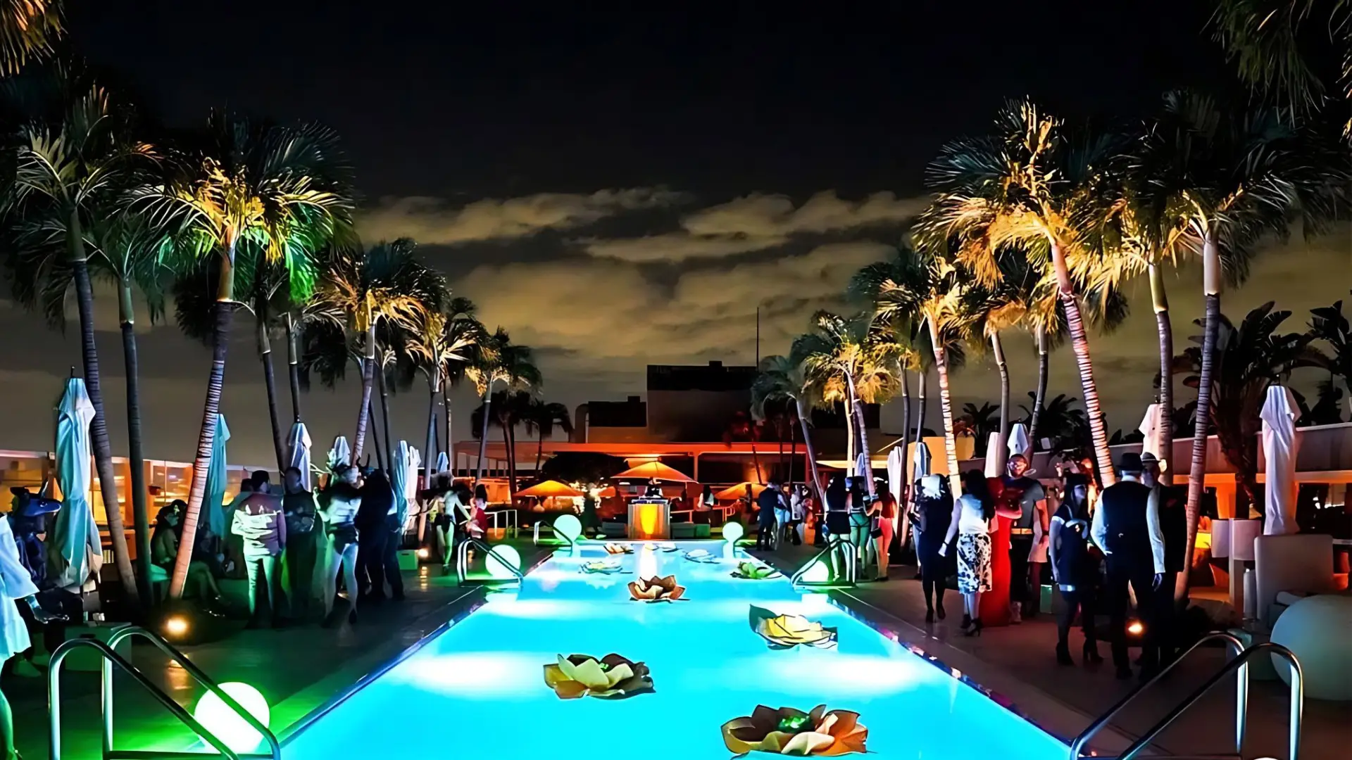 Enjoy the beach bar at 1 Hotel South Beach, with white couches and palm trees, a top choice among the best party hotels in Miami.