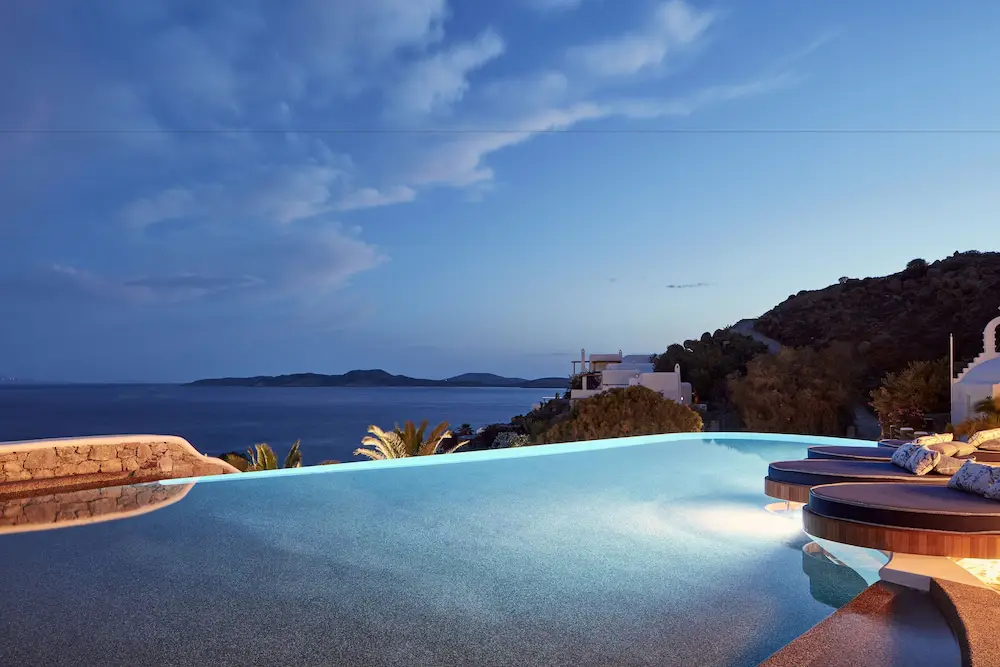 Enjoy the serene pool view at dusk from Katikies Mykonos, one of the best hotels in Mykonos for party enthusiasts.