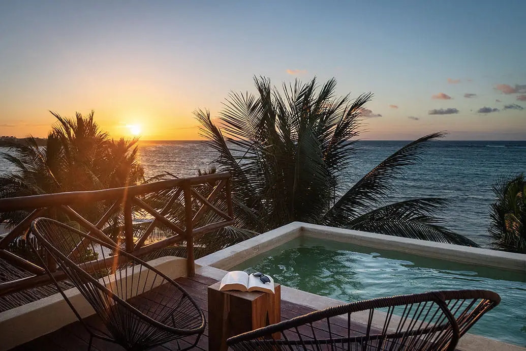 A stunning sunset view of the ocean and pool at Mereva, one of the best party hotels in Tulum.