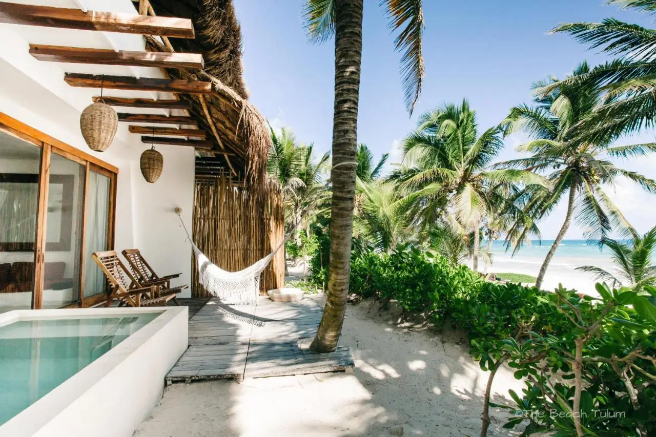 A cosy beach house at The Beach, featuring a hammock and hot tub, perfect for relaxing at the best party hotels in Tulum.