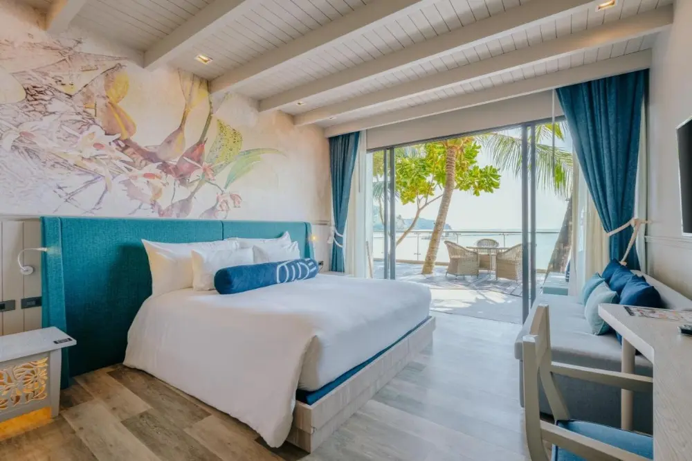 A cosy hotel room at Hotel Tide featuring a large bed and an ocean view, perfect for couples seeking the best resorts in Phuket.