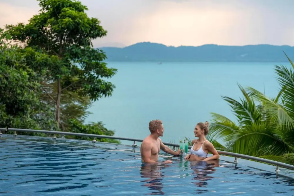 A couple enjoying a relaxing moment in a pool at one of the best resorts in Phuket for couples.