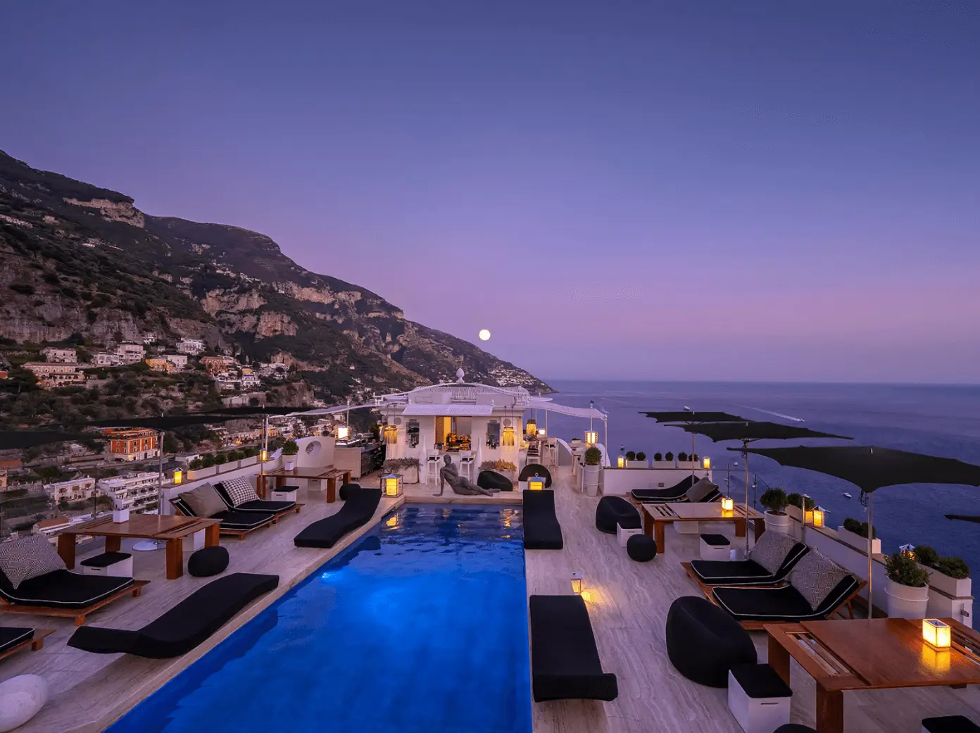 A beautiful sunset view of the hotel’s pool side and the beach at hotel Villa Franca, one of the best romantic hotels in Positano.