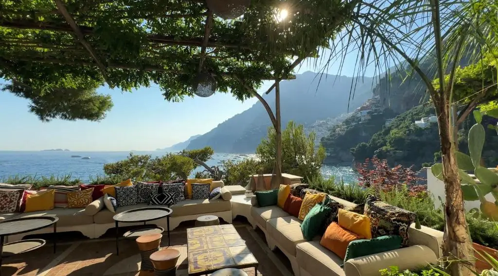 A stunning view of a beach and a mountain from Villa Treville, one of the best romantic hotels in Positano.