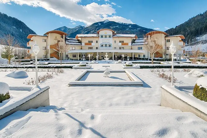 Alpenpalace Luxury Hideaway & Spa Retreat, a big white building in the snow, is one of the best ski hotels in Italy.