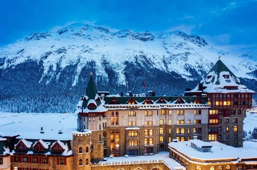 A winter scene featuring a grand ski hotel in Switzerland with snow-covered mountains, highlighting this ski destination.