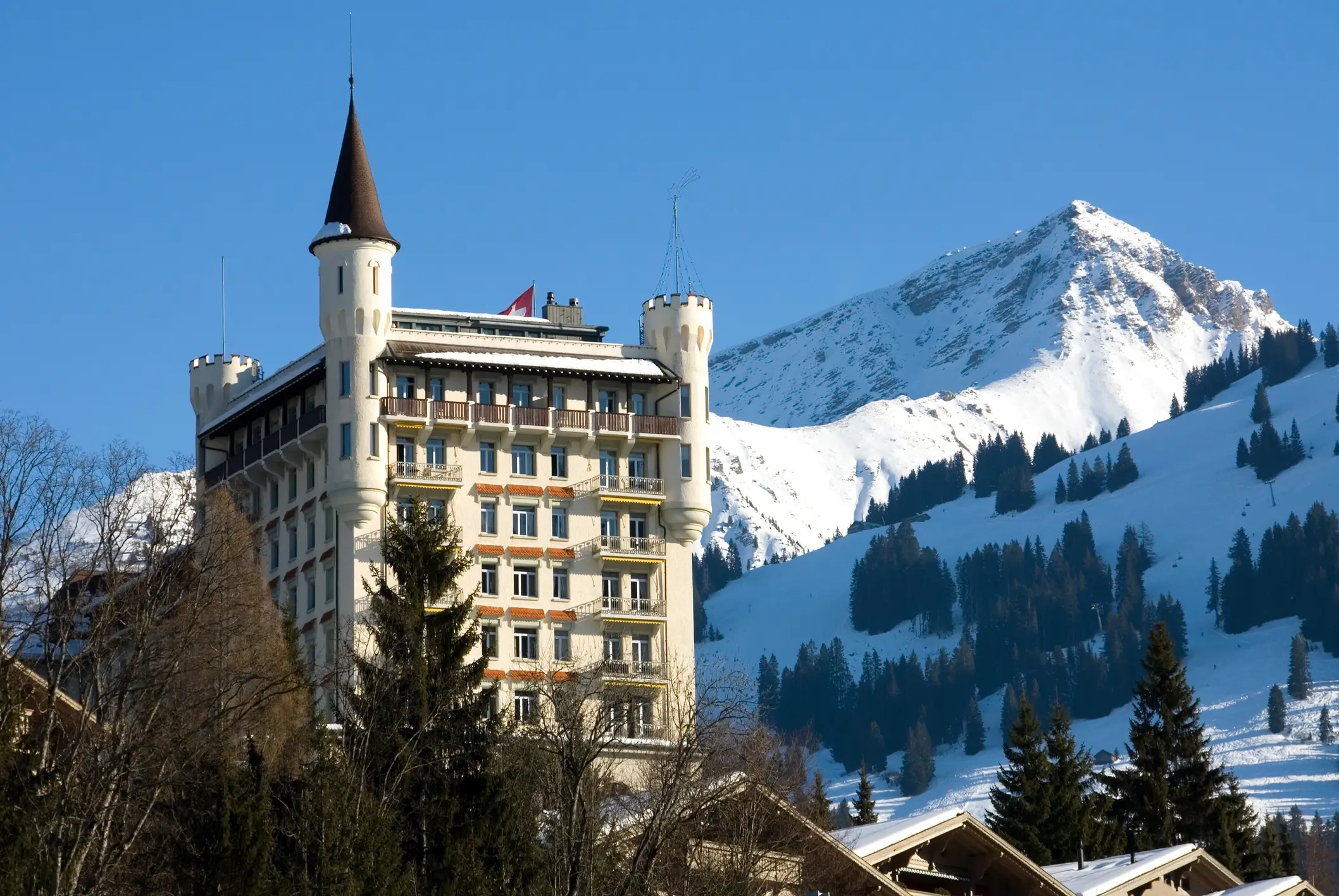 A tall building in Gstaad, showcasing one of the best ski resorts in Switzerland with its charming architecture and snowy backdrop.