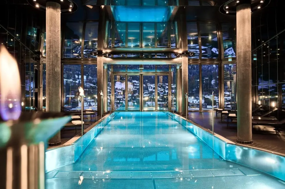 Enjoy the long indoor pool with a glass floor at The Omnia Zermatt, one of the best snowboard hotels in Switzerland.