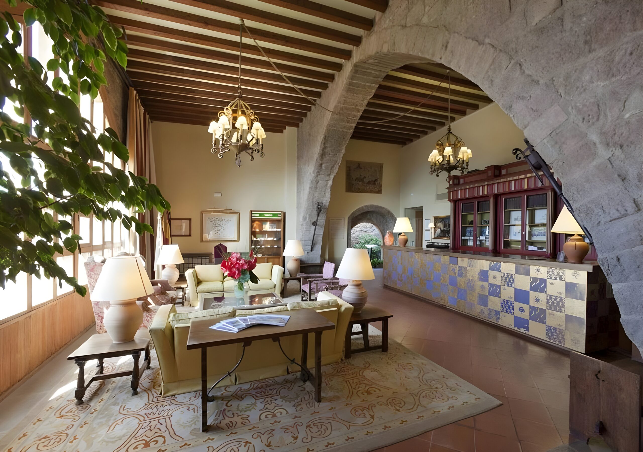 The lobby of Parador de Cardona, Spain, highlights a warm reception space with charming architectural details of a castle hotel of the world.