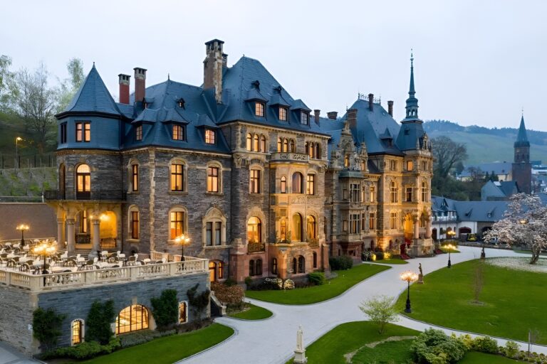 A beautiful castle located on a lush green hill, highlighting the scenic elegance of castle hotels in the world.