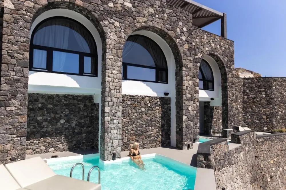 A woman relaxes in the pool at Charisma Suites, a luxury resort among the best design hotels in Santorini.