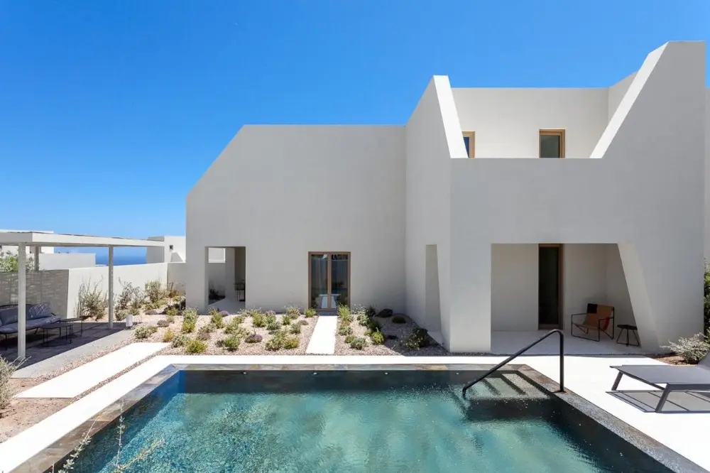 Modern white house featuring a pool, representing Noūs Santorini, one of the best design hotels in Santorini.