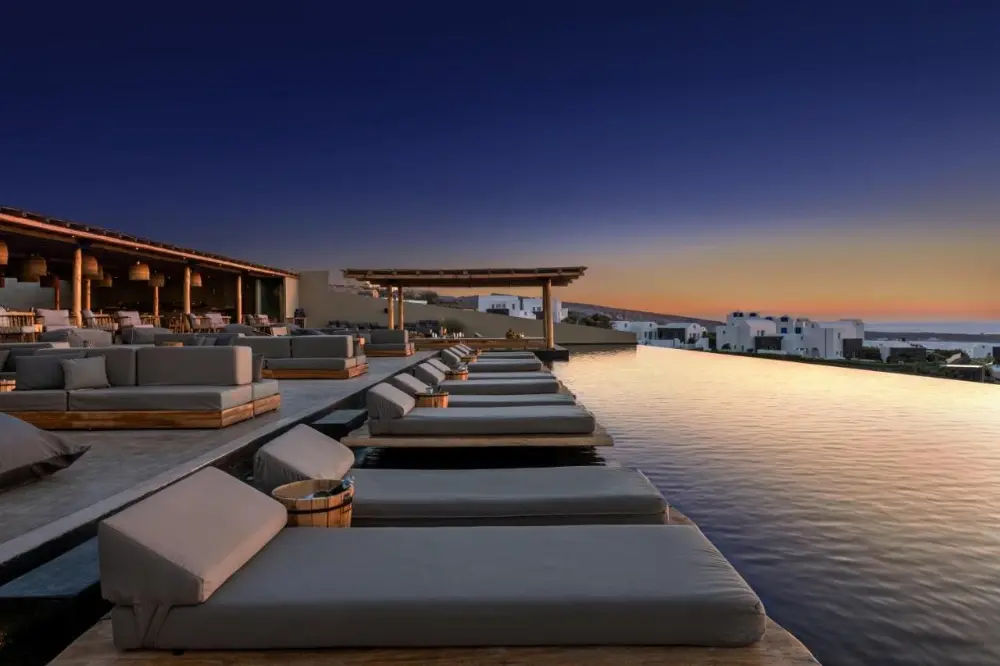 un loungers in front of an infinity pool at a family-friendly hotel in Santorini.