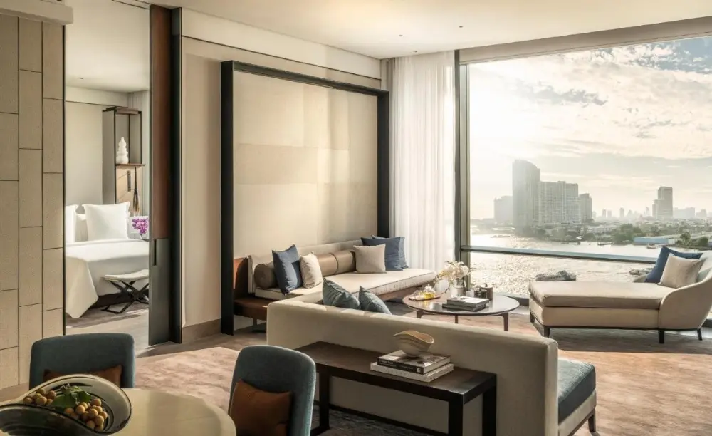 A modern hotel room at Four Seasons, a luxury hotel in Bangkok, Thailand, showcasing a stunning view of the river and the city.