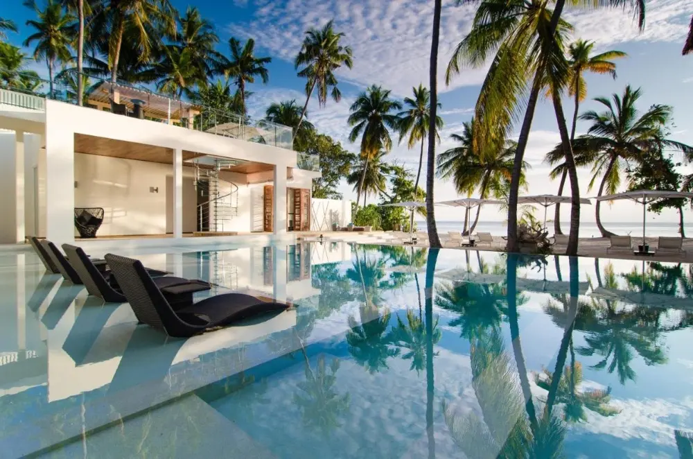 Beautiful white villa with a pool and palm trees, located in the luxurious Amilla Fushi resort, Baa Atoll, a luxury resort in Maldives Island.