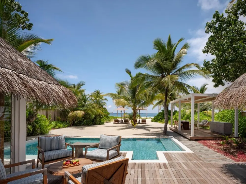 Tranquil poolside lounge with a thatched roof, located at the exquisite luxury hotel in Maldives Island, Six Senses Kanuhura.