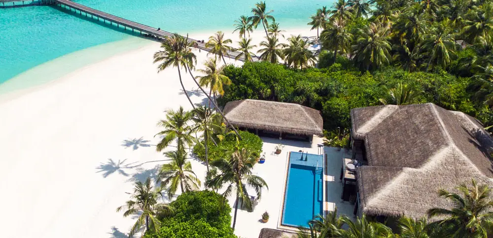 Bird's-eye view of Velaa Private Island, illustrating a luxury resort in Maldives and a refreshing pool situated in a tropical landscape.