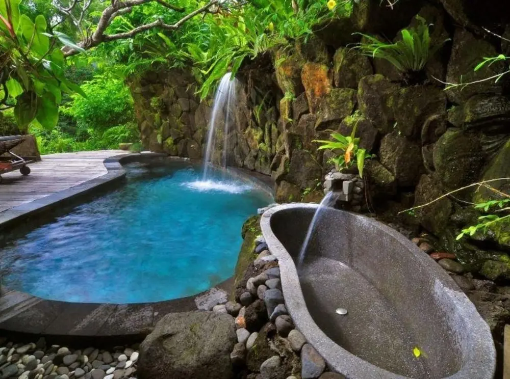 Surrounded by jungle, the luxurious stone pool at Adiwana Dara Ayu Villas, one of Bali's most Instagrammable hotels, creates a serene and peaceful atmosphere.