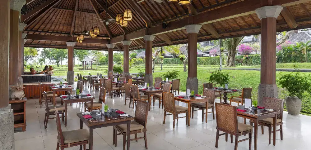 A stunning dining outdoor space of the Visesa Ubud, an instagrammable hotel in Bali, surrounded by tropical gardens.