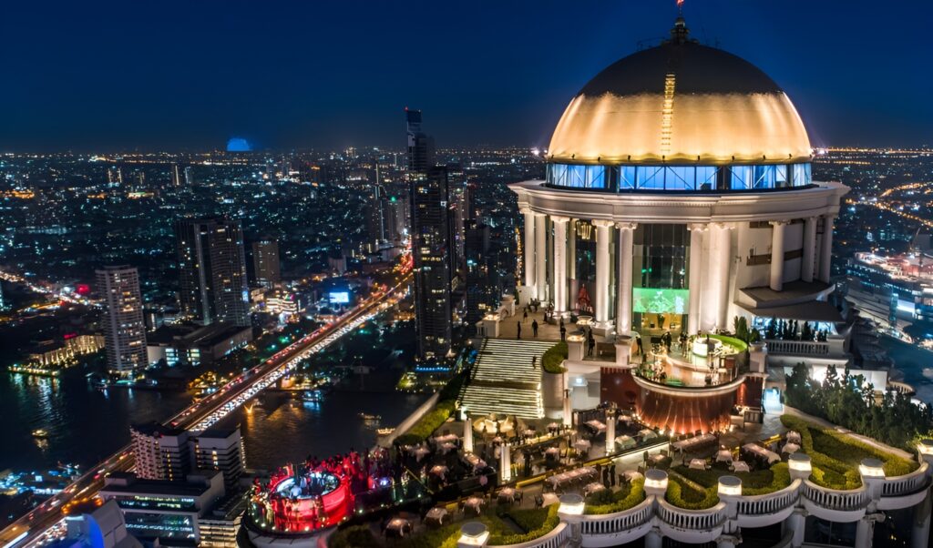 A festive gathering of people surrounding a circular dance floor at the Lebua, a party hotel in Bangkok.