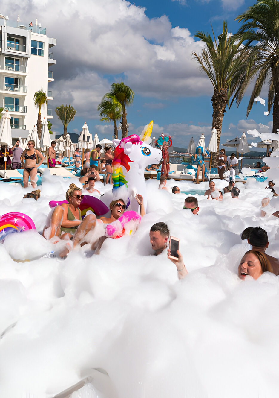 Guests reveling in a foam-filled pool at Amàre Beach Hotel, capturing the essence of a festive party hotel in Ibiza.