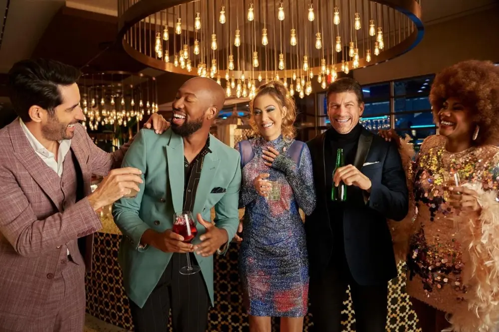 A group of friends smiling and posing together for a photo at a lively bar in Sahara, one of the best party hotels in Las Vegas.