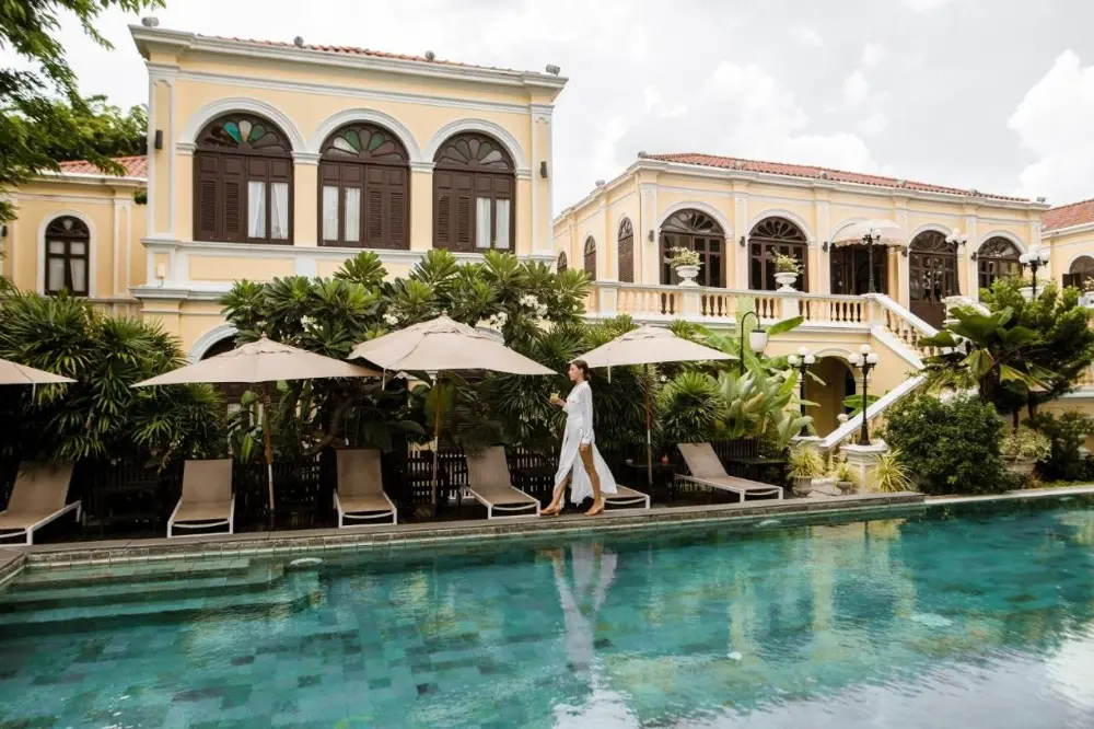 A woman stands in the pool at Praya Palazzo, a romantic hotel in Bangkok, enjoying the lovely atmosphere.