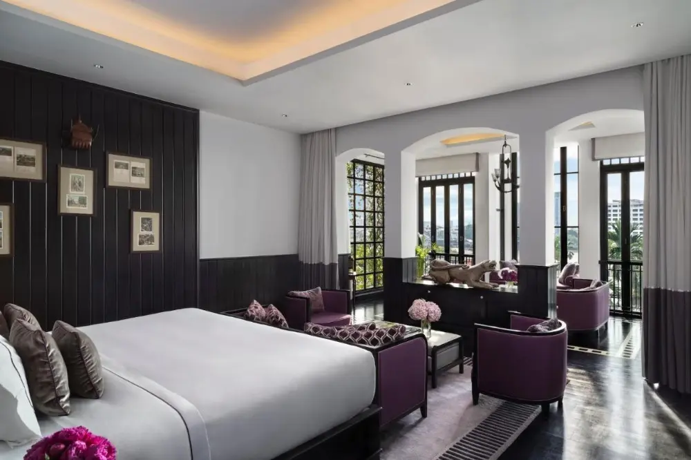 A large bedroom featuring purple accents and black walls, showcasing the romantic hotel in Bangkok, The Siam.