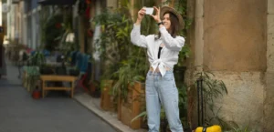 An influencer taking a picture with a suitcase next to her, showcasing social selling for hotels.