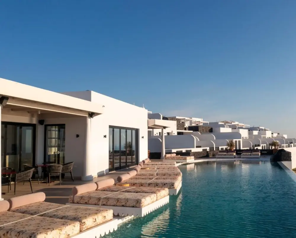 Relax by the pool at Cresanto Luxury Suites, one of the best spa hotels in Santorini, featuring a luxurious lounge area.