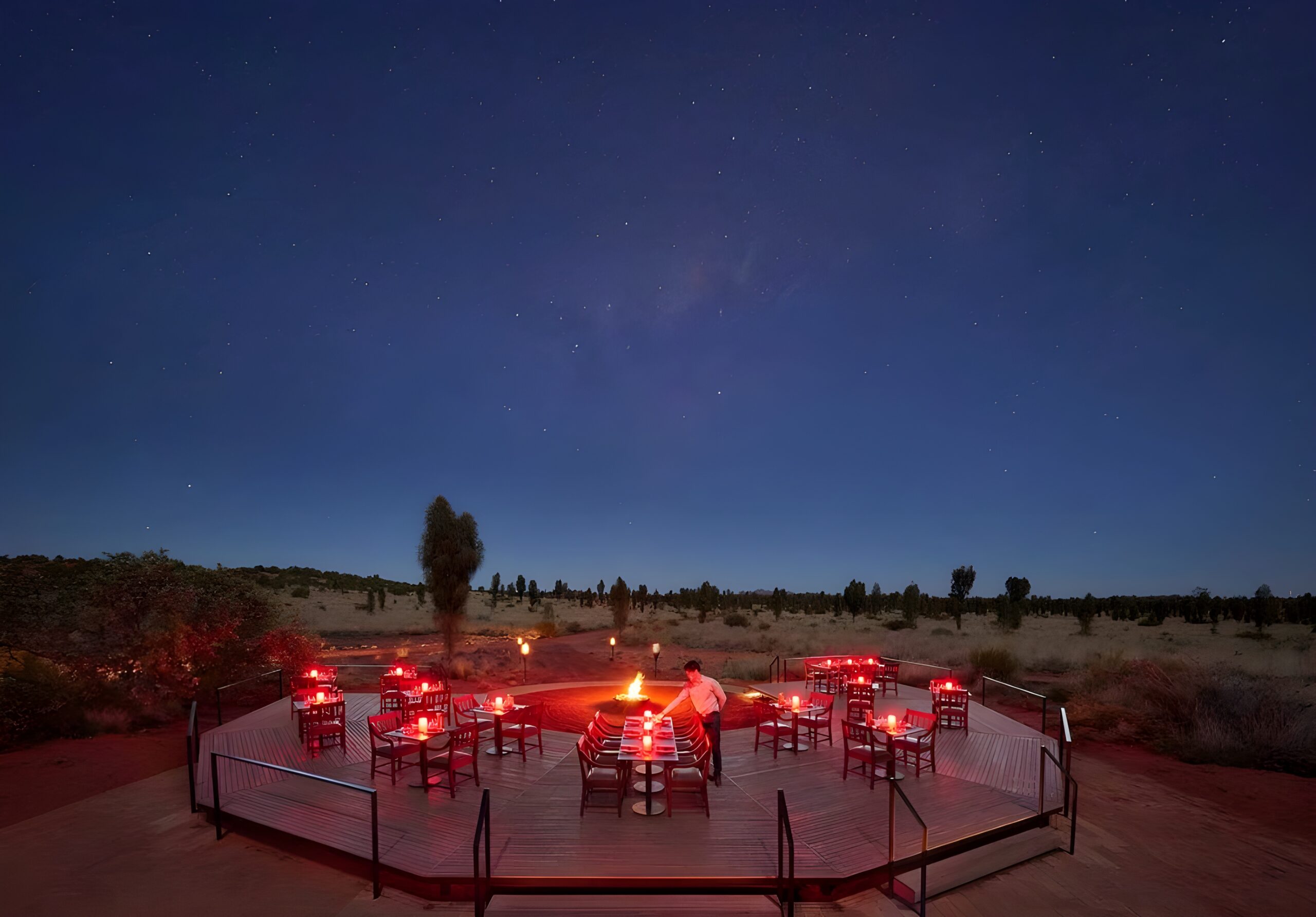 A night scene of a table in the desert, illuminated by stars, capturing the essence of a stargazing hotel at Longitude 131° in Australia.