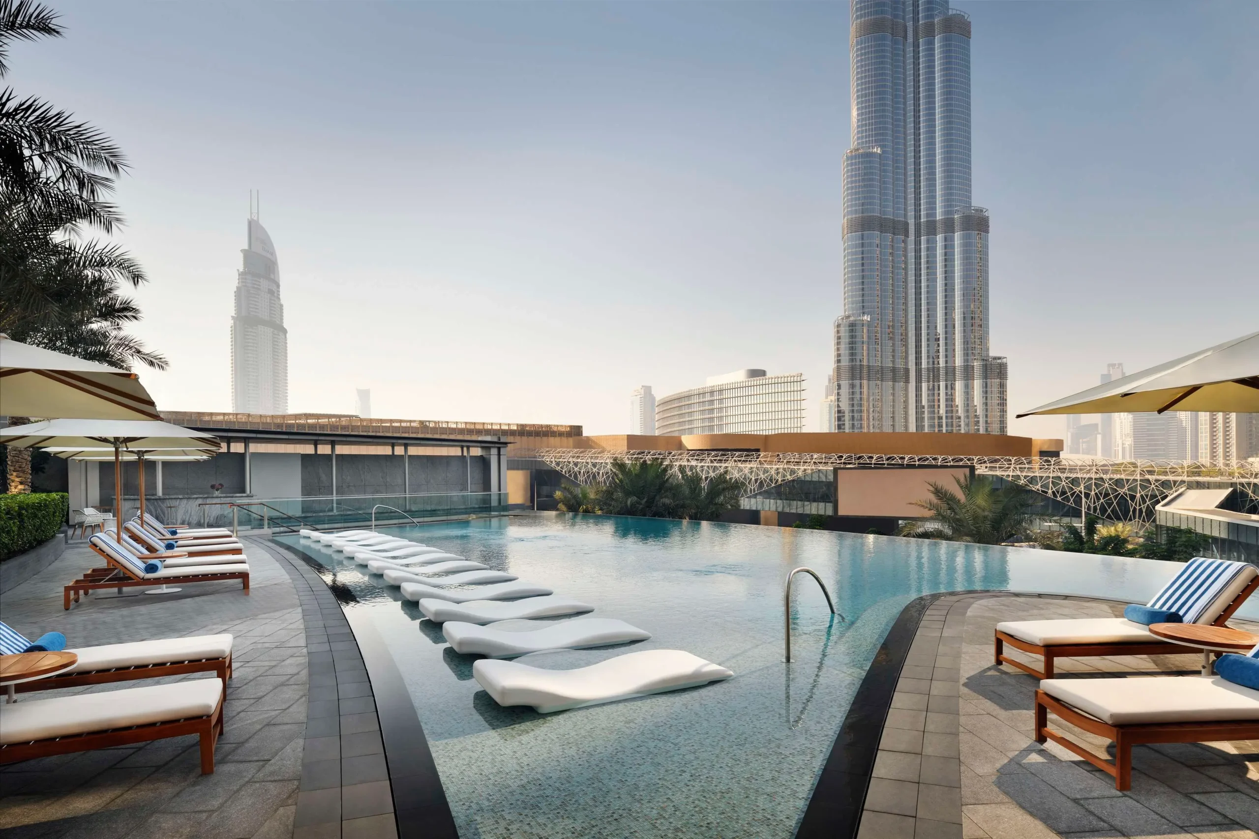 A stunning view of the pool at Address Boulevard, a luxury hotel in Dubai, with the iconic Burj Khalifa in the background.