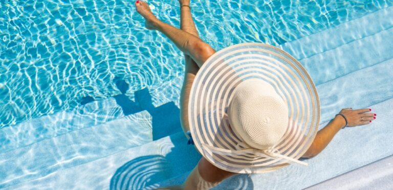 A woman in a white hat and swimsuit enjoys her vacation thanks to the help of AI travel assistants.