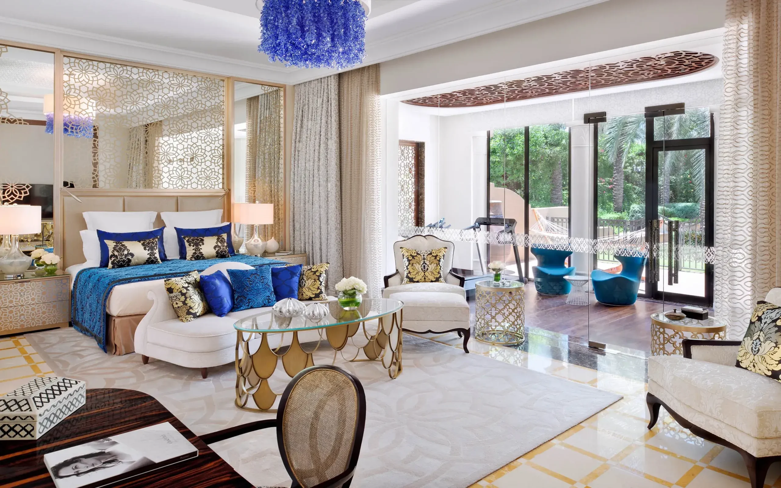 A beautifully designed bedroom at One & Only The Palm, a luxury hotel in Dubai, showcasing a harmonious blend of blue and gold decor for a lavish ambiance.